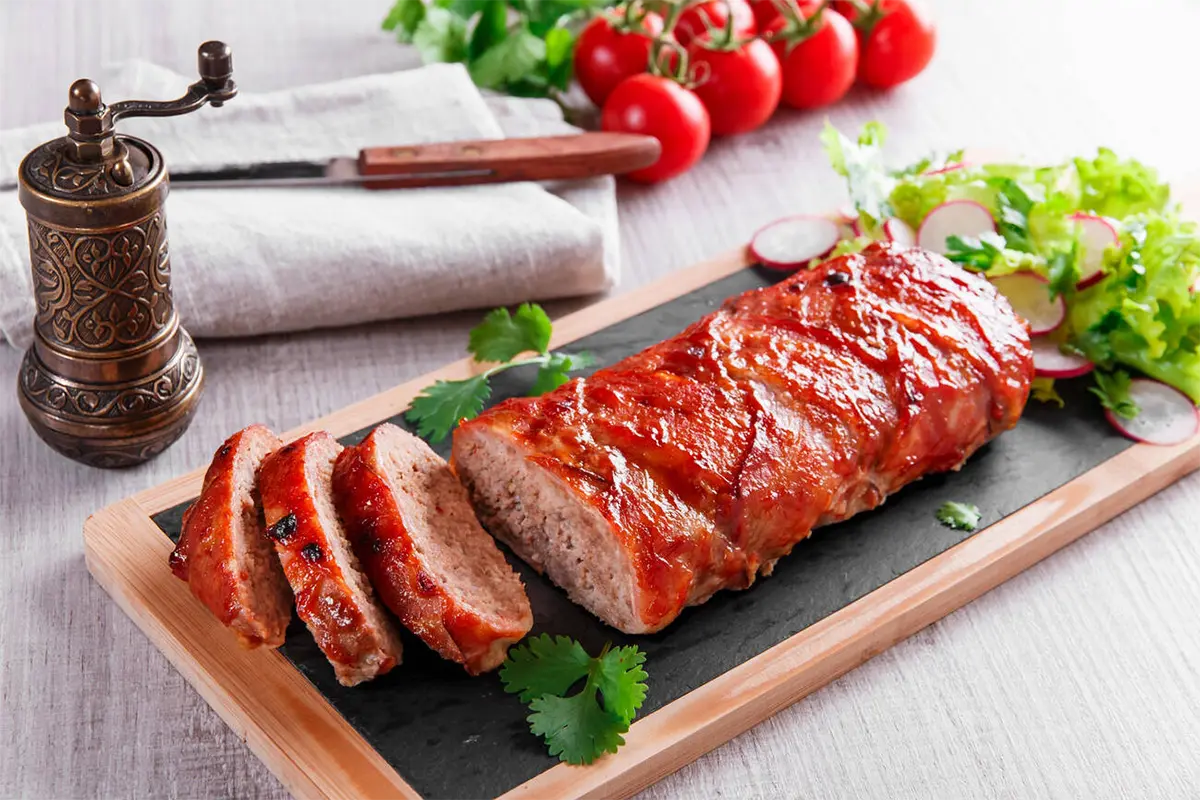 A beautifully set dinner table with a freshly baked meatloaf at the center