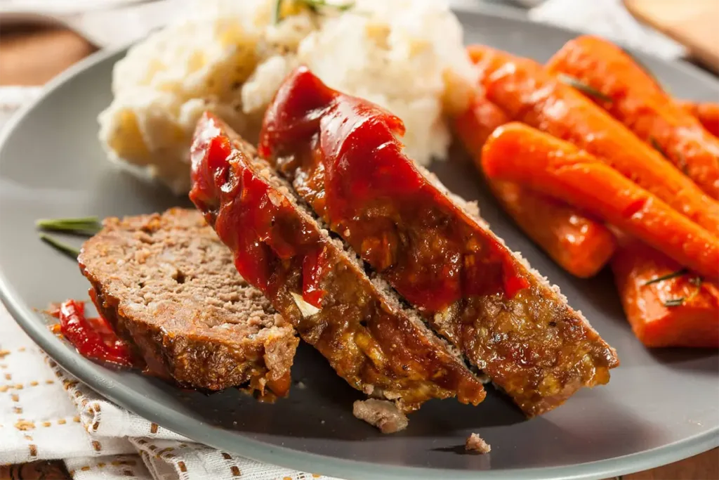 Gourmet meatloaf served on a dinner table with garnishes