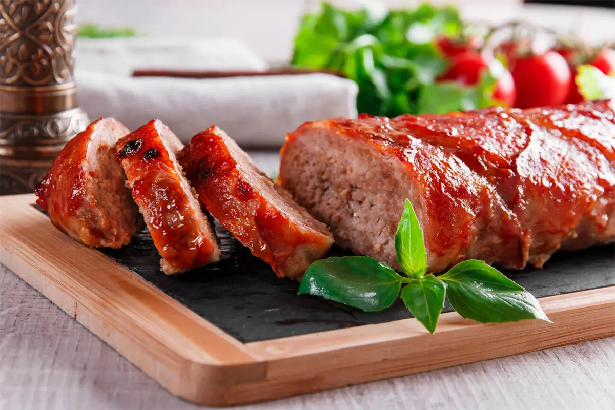 Ingredients for meatloaf being mixed in a kitchen bowl