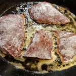 Chef preparing tenderized meat in a professional kitchen